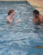 Vivek holding on to the side of the pool. Madeleine laughing.